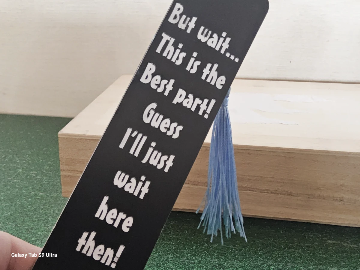 Black inspirational bookmark with blue tassel – “But wait… this is the best part!”